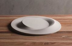 two white plates sitting on top of a wooden table