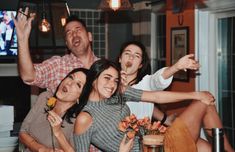 a group of people sitting around each other at a table with food in front of them