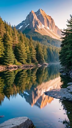 the mountains are reflected in the still water of this lake, with pine trees on both sides