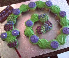 a birthday cake made to look like grapes with purple and green icing on it