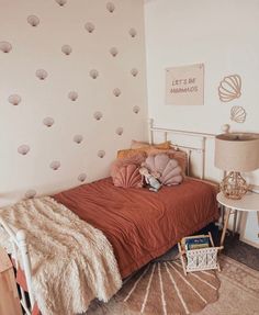 a bedroom with a bed, nightstand and wallpaper on the walls that has seashells all over it