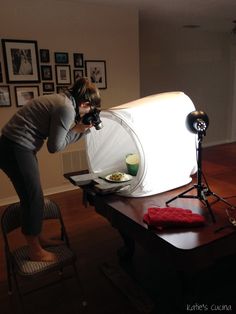 a woman taking a photo in front of a white light