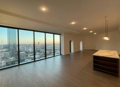 an empty room with large windows overlooking the city