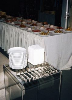 a table with plates and silverware is set up for a buffet style party or event