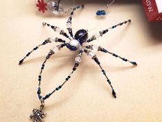 a close up of a spider on a table with beads and glass bead decorations