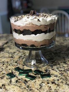 a cake sitting on top of a counter covered in frosting and toppings,