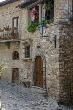 an old stone building with flowers on the balconies