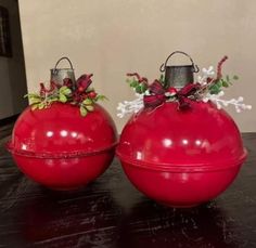 two red christmas ornaments sitting on top of a table