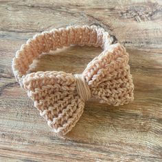 a crocheted bow tie sitting on top of a wooden table