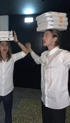 two women are balancing boxes on their heads