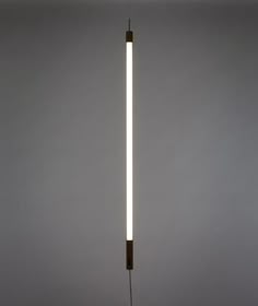 a light that is on top of a wooden pole in the middle of a room