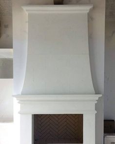 a white fireplace in a living room next to a wall