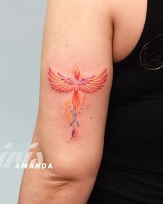 a woman's arm with a tattoo on it that has an orange bird painted on it