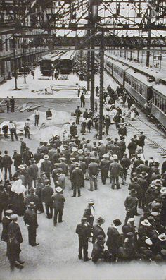 an old black and white photo of people at a train station