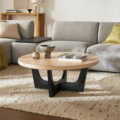 a living room with a couch, coffee table and pillows on the carpeted floor