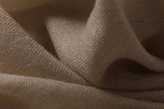 a close up view of the fabric on a white cloth textured with natural linen