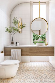 a bathroom with a sink, toilet and bathtub next to a plant in the window