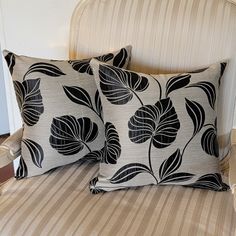 two black and white pillows sitting on top of a bed