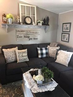 a living room with black couches and white pillows on the coffee table in front of it