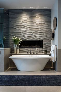 a bathroom with a large bathtub next to a fireplace in the middle of it