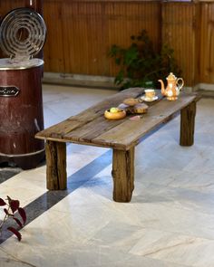 a wooden bench sitting on top of a tiled floor next to a potted plant