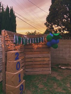 a fence with balloons and streamers hanging from it's sides in the evening