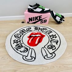 the rolling stones door mat is next to a pair of nike shoes and a pink box