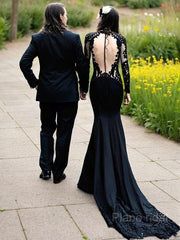 a man and woman dressed in formal wear walking down a path with their back to the camera