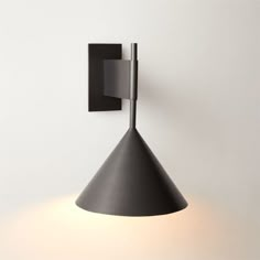 a black wall light mounted on the side of a white wall