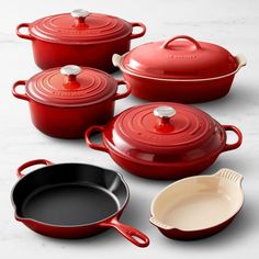 red pots and pans on a white table