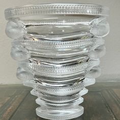 a stack of clear glass dishes sitting on top of a wooden table