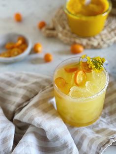 a glass filled with orange juice sitting on top of a table next to other dishes