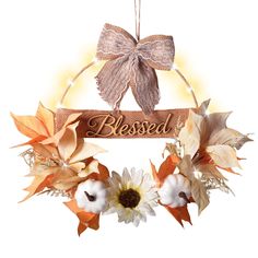 a wreath with flowers hanging from it's side and the word, blessed on top