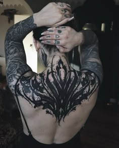 a woman with tattoos on her back and arms