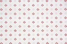 a red and white wallpaper with small flowers on the bottom half of it's surface