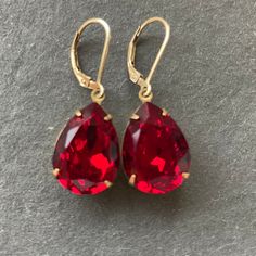 YUMMMMY color of the year 2023 VIVA MAGENTA ( the name is confusing, but it's really a red color) generously 18mm sized pear-shaped glass gems have been given a coating for EXTRA sparkle with These are set in gold plate over brass so they go perfectly with 14k gold filled leverback earwires.   The approx. Total length is 1.25" but these pack a lot of punch for their lightweight size! I AM OFFERING THESE IN SILVER  in a different listing . If you do not see them please contact me.  Your jewelry w Ruby Crystal Aesthetic, Gold Red Earrings, Gem Earring, Glam Earrings, Bridesmaids Jewelry, Crystal Teardrop Earrings, Red Pendants, Ruby Crystal, Red Jewelry