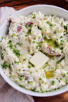 a white bowl filled with mashed potatoes and peas