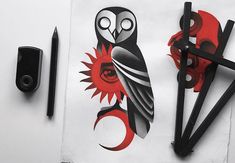 two black scissors and some red designs on a piece of paper