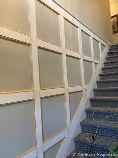 a set of stairs leading up to a wall with glass panels on the sides and bottom