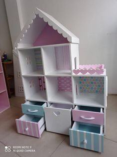 the doll house is made out of cardboard and painted pink, blue, and white