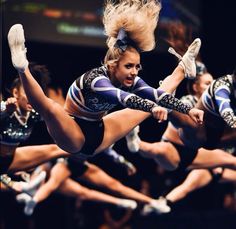 a group of cheerleaders are doing tricks in the air with their legs spread out