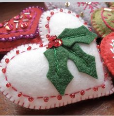 several heart shaped ornaments with red, green and white decorations on them sitting on a table