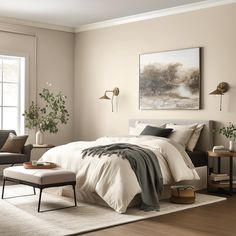 a bedroom with a bed, chair, ottoman and pictures on the wall above it