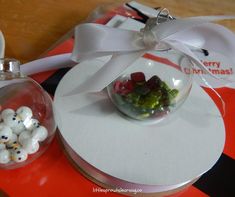 a glass ornament with candy in it sitting on top of a white plate