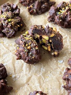 chocolate covered cookies with nuts and sprinkles on top of parchmented paper