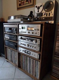 an old fashioned stereo system sitting on top of a wooden cabinet next to a record player