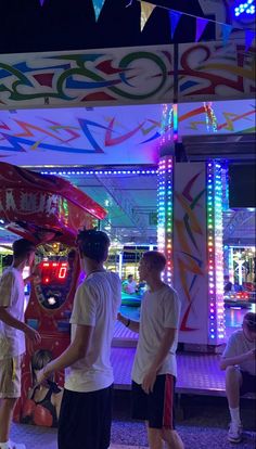 some people are standing in front of a carnival ride