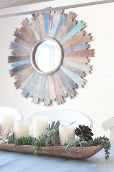 candles and succulents are arranged on a tray in front of a mirror