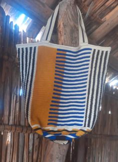 Discover Our Wayuu Tote Bag Check out our special Wayuu tote bag! Handmade by the Wayuu people of La Guajira, Colombia, each bag stands out with its vibrant crochet pattern. It's perfect for any occasion, from a day at the beach to casual daily outings. 𝐃 𝐈 𝐌 𝐄 𝐍 𝐒 𝐈 𝐎 𝐍 𝐒 Height: 39 cm (+-3cm) / 15.3"  Base: 30 cm (+-3cm)  / 11,8" Strap:  Length: 65 cm (+-5 cm) / 25"   Width: 4.5 cm (+-1 cm) /  1.9" Unique Handcrafted Quality The tote features a unique, colorful design. As each bag is Artistic Yellow Tote Bag, Yellow Artistic Bag For Daily Use, Artistic Yellow Bag For Daily Use, Artisan Beige Travel Bag, Yellow Handwoven Shoulder Bag, Traditional White Travel Bag, Artisan Bucket Bags For Travel, Large Handwoven Shoulder Bag For Travel, Large Multicolor Bag With Handles