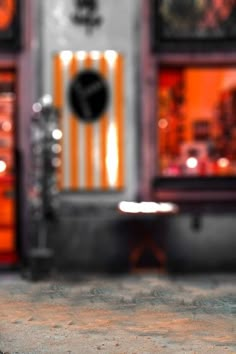 an orange and black clock sitting on top of a table next to a store front